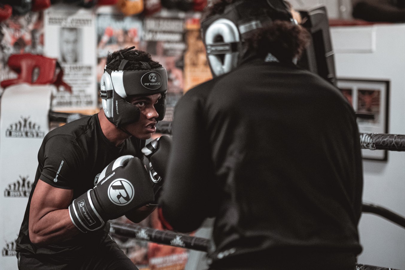 boxer wearing black and silver headguard and gloves whilst sparring