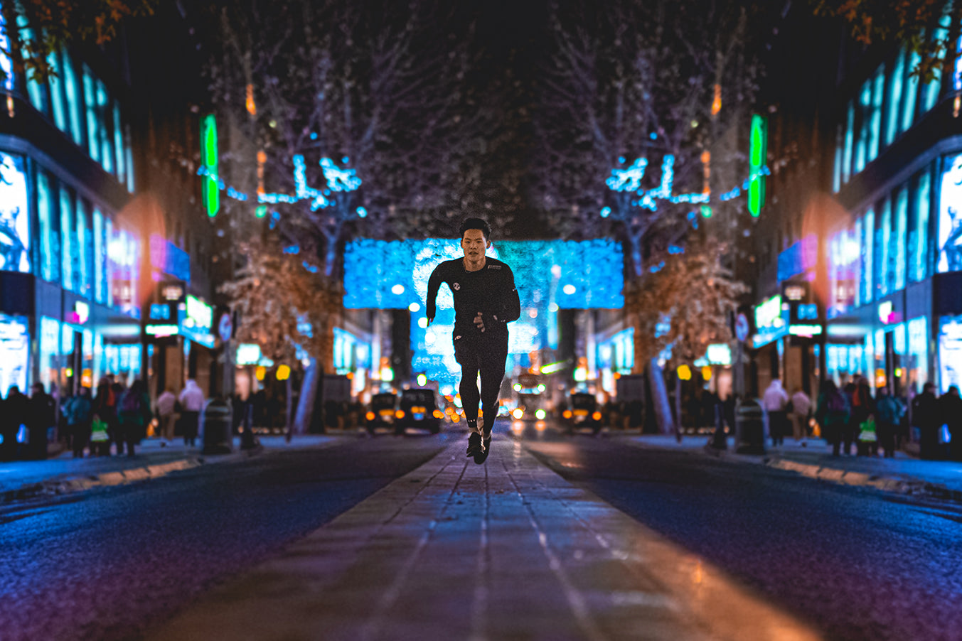 Man sprinting in street late at night. Streets well lit with neon lights.